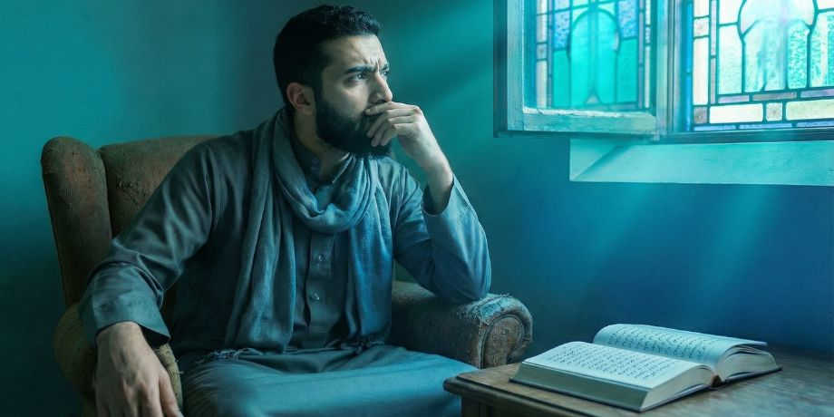 صورة تحتوى على رجل يتسائل ويفكر وأمامه إنجيل