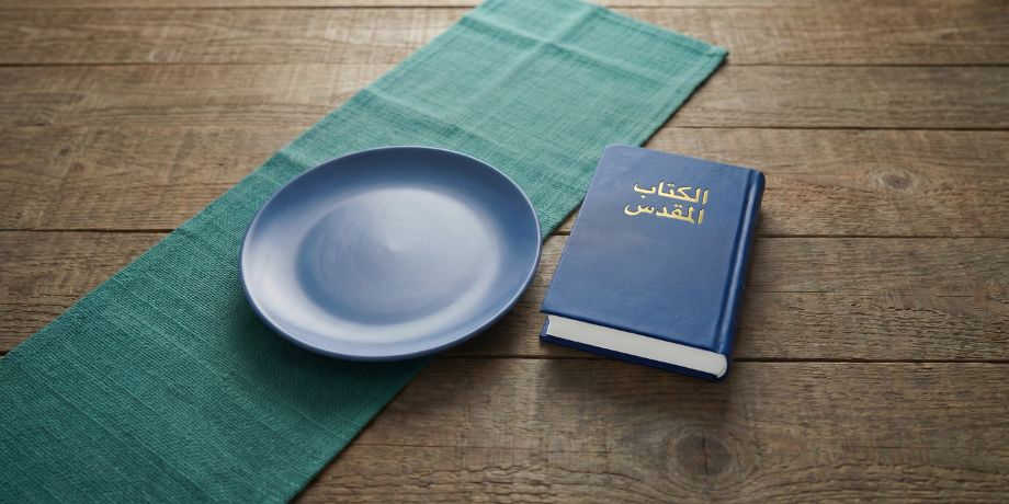 صورة تحتوي على كتاب مقدس وطبق فارغ