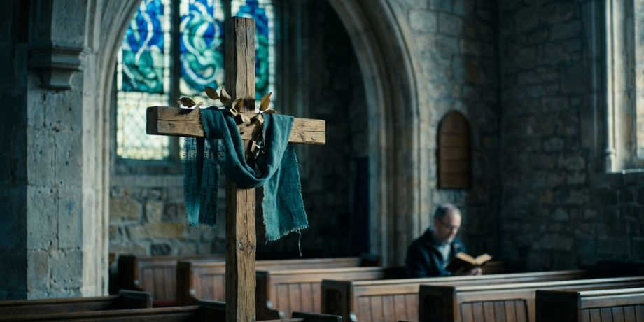  صورة تحتوي على كنيسة وصليب ورجل يقرأ الإنجيل